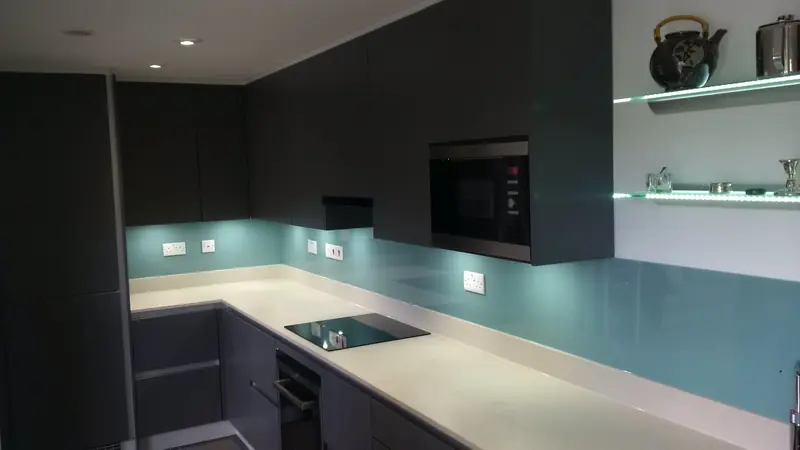 Kitchen installation with teal glass splashback in Esher Surrey