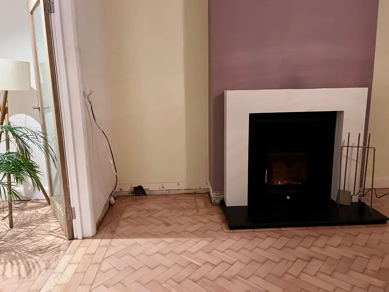 Completed living room renovation with parquet flooring and fireplace in Esher Surrey